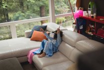 Дівчина використовує гарнітуру віртуальної реальності на дивані вдома — стокове фото