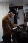 Homem preparando café preto na cozinha em casa — Fotografia de Stock