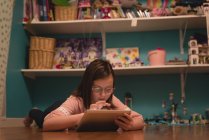 Девушка, использующая цифровой планшет в гостиной дома — стоковое фото