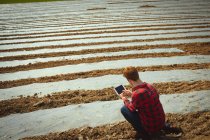 Человек заднего вида с помощью цифрового планшета в поле — стоковое фото