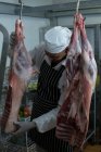 Metzger hält frisches Fleisch in Metzgerei — Stockfoto