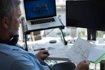 Чоловік готує архітектурного дизайну на ноутбуці в домашніх умовах — стокове фото