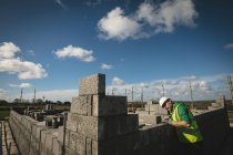 Концентрированный инженер, осматривающий стену на строительной площадке — стоковое фото