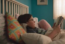 Menina lendo um livro no quarto em casa — Fotografia de Stock