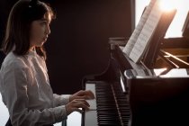 Adorável estudante tocando piano na escola de música — Fotografia de Stock