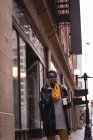 Mujer joven hablando por teléfono móvil en la calle de la ciudad - foto de stock