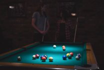 Пара, играющая в бильярд в ночном клубе — стоковое фото