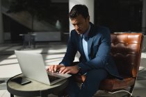 Empresário sério usando laptop no escritório — Fotografia de Stock