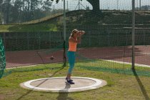 Atleta femminile che pratica tiro messo in sede sportiva — Foto stock