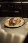 Pedaços de frango mantidos em prato na cozinha do restaurante — Fotografia de Stock