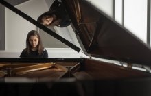 Adorable colegiala tocando piano en la escuela de música - foto de stock