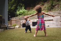 Siblings playing in the garden on a sunny day — Stock Photo