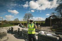 Ingegnere con auricolare VR in cantiere in una giornata di sole — Foto stock