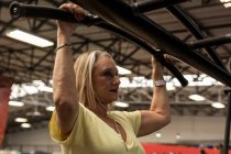 Behinderte Frau trainiert an Gerät im Fitnessstudio — Stockfoto