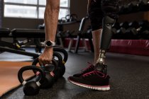 Faible section de femme handicapée faisant de l'exercice sur la machine dans la salle de gym — Photo de stock