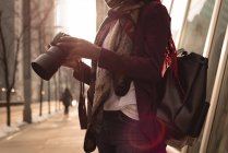 Mid section of woman with digital camera in the city — Stock Photo