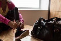 Женщина-инвалид, завязывающая шнурки в спортзале — стоковое фото