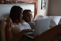 Lesbisches Paar benutzt Laptop im Schlafzimmer zu Hause — Stockfoto