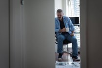 Зрілий чоловік має каву під час роботи вдома — стокове фото