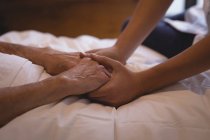 Close-up de fisioterapeuta segurando a mão de uma mulher idosa — Fotografia de Stock