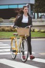 Belle femme avec vélo traversant la route — Photo de stock