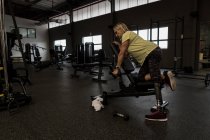 Disabled woman exercising on machine in the gym — Stock Photo