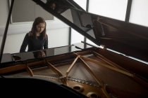 Прекрасная школьница, играющая на фортепиано в музыкальной школе — стоковое фото
