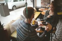 Молодая пара разговаривает за чашечкой кофе в кафе — стоковое фото