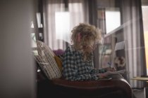 Женщина-блоггер пишет на блокноте в гостиной дома — стоковое фото