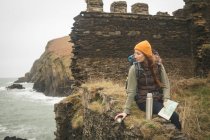 Bella escursionista femminile con mappa guardando il mare — Foto stock