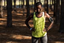 Exhausted female athlete taking a break in the forest — Stock Photo