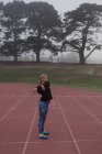 Athletin wärmt sich auf der Laufstrecke auf — Stockfoto