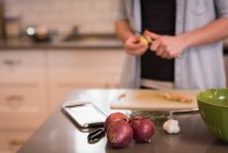 Средняя часть женщины режет овощи на кухне дома — стоковое фото