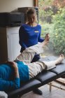 Фізіотерапевт, який допомагає старшій жінці з фізіотерапевтичними вправами вдома — стокове фото