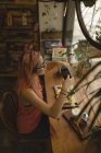 Jeune femme photographiant de la nourriture servie sur la table dans un café — Photo de stock