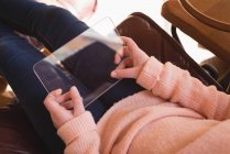 Menina usando tablet digital de vidro na sala de estar em casa — Fotografia de Stock