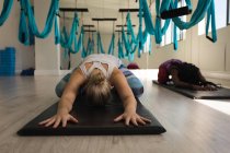 Deux femmes effectuant des exercices de yoga dans un studio de fitness — Photo de stock