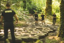 Entraînement des hommes sur le parcours d'obstacles de pneus au camp d'entraînement — Photo de stock