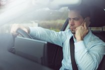 Empresário falando no celular em um carro moderno — Fotografia de Stock