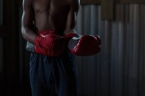 Partie médiane du boxeur masculin pratiquant la boxe dans un studio de fitness — Photo de stock