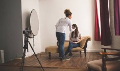 Photographe femelle enregistrant une interview à l'aide d'un enregistreur vocal dans un studio photo — Photo de stock