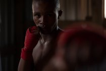 Молодий чоловічий боксер практикує бокс у фітнес-студії — стокове фото
