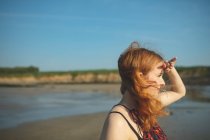 Acercamiento de Mujer mirando hacia el mar en un día soleado - foto de stock