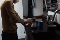 Homme préparant le café noir dans la cuisine à la maison — Photo de stock