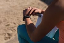 Partie médiane de l'athlète féminine utilisant smartwatch — Photo de stock