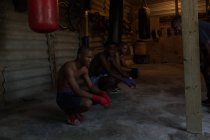 Jovens boxers do sexo masculino relaxando no estúdio de fitness — Fotografia de Stock