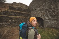 Ritratto di bella escursionista donna con zaino che guarda la macchina fotografica — Foto stock