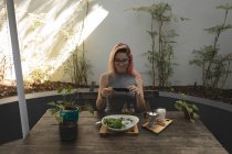 Junge Frau fotografiert Essen, das in einem Café auf dem Tisch serviert wird — Stockfoto