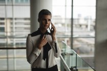 Donna d'affari che parla al cellulare in ufficio — Foto stock