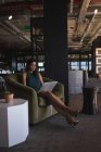 Бізнес-леді сидить на стільці і використовує ноутбук в офісі — стокове фото